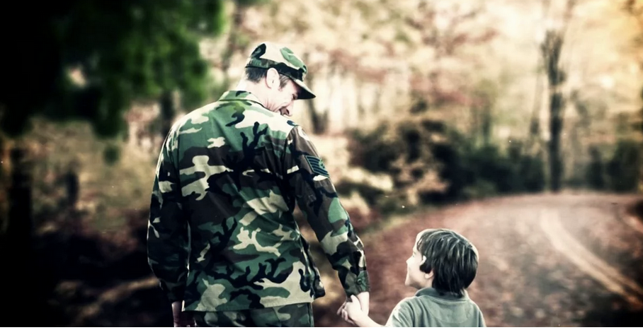 video screen shot of soldier holding boy's hand 