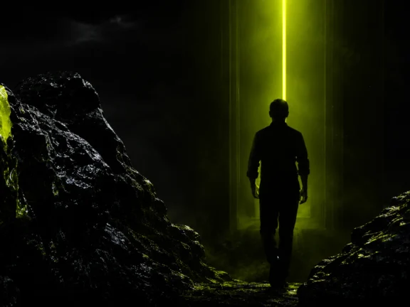 Figure walking toward a shaft of green light